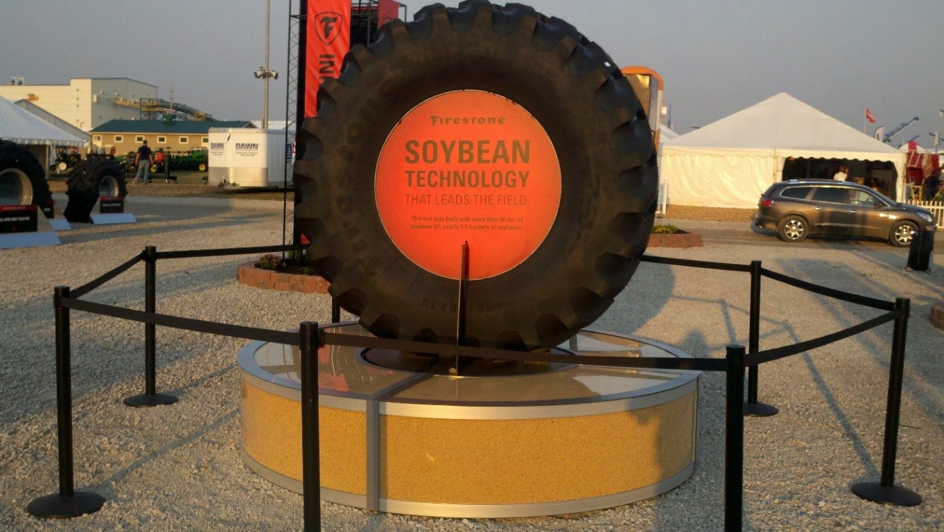 Bridgestone soy tire on display with the words, "Soybean technology that leads the field" on a sign in the center
